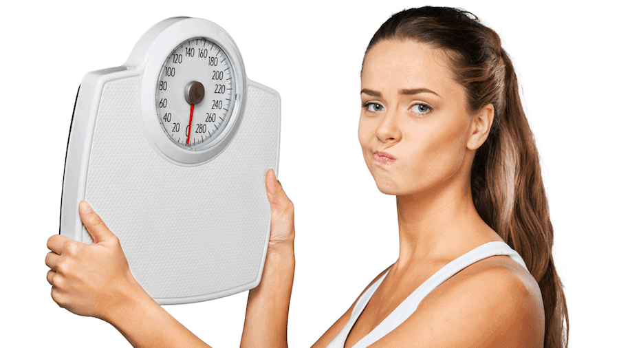 Image showing a woman holding up a weighing scale with a frown