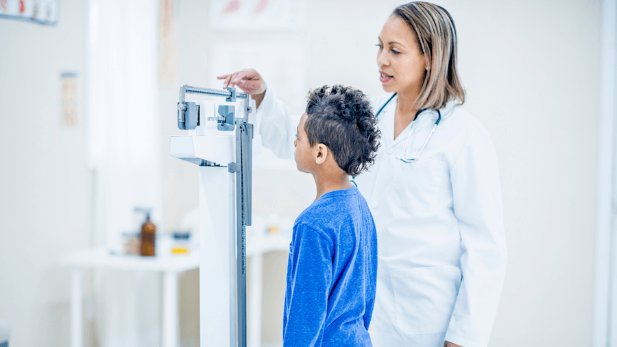 A boy getting his height measured by a doctor