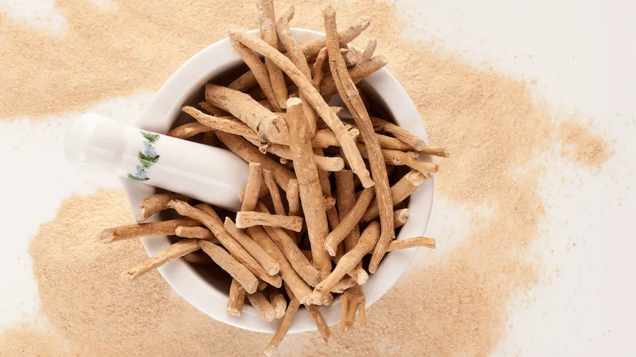 Image showing a white mortar and pestle with ashwagandha twigs in it