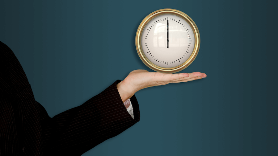 Image showing a hand holding a golden clock