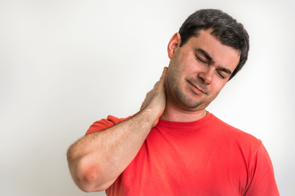 A guy in a red T-shirt holding his neck in pain