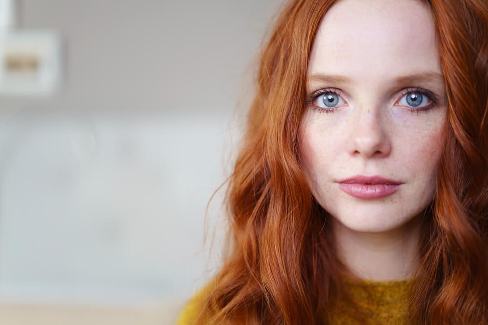 A young girl showing physical signs of viking ancestry like red hair, blue eyes, a broad forehead, and a prominent chin.