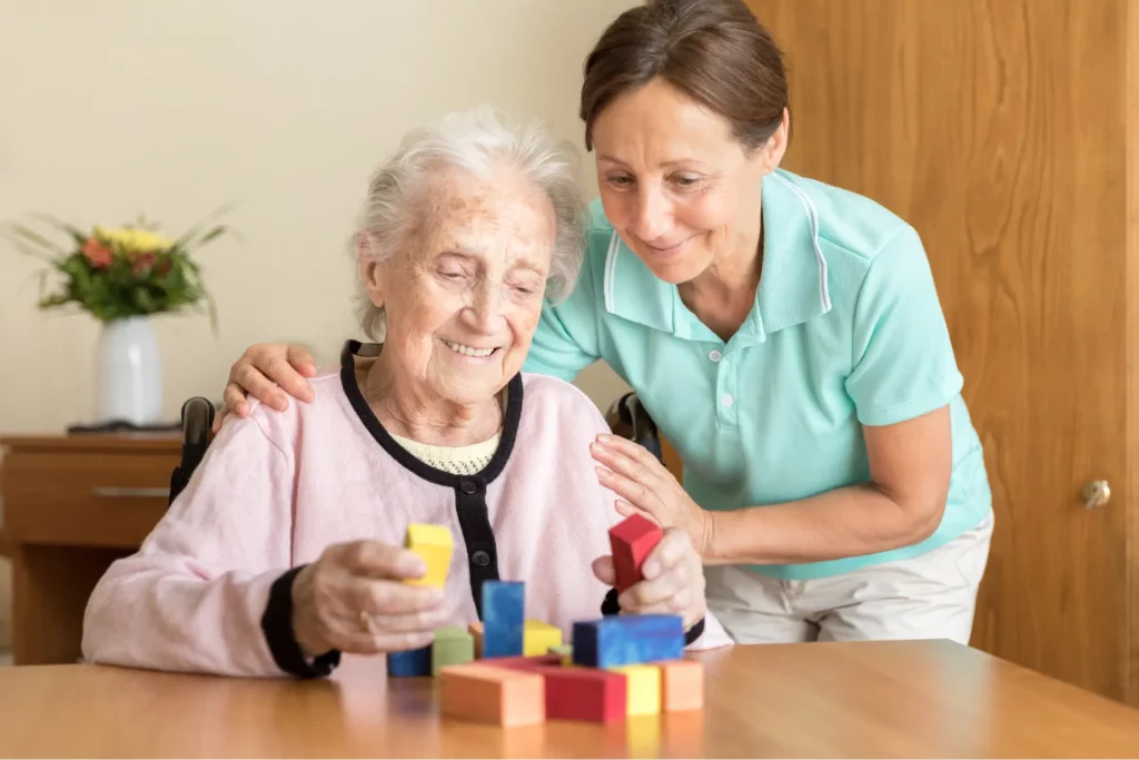 An elderly woman suffering with Lewy body dementia is comforted by her caretaker.