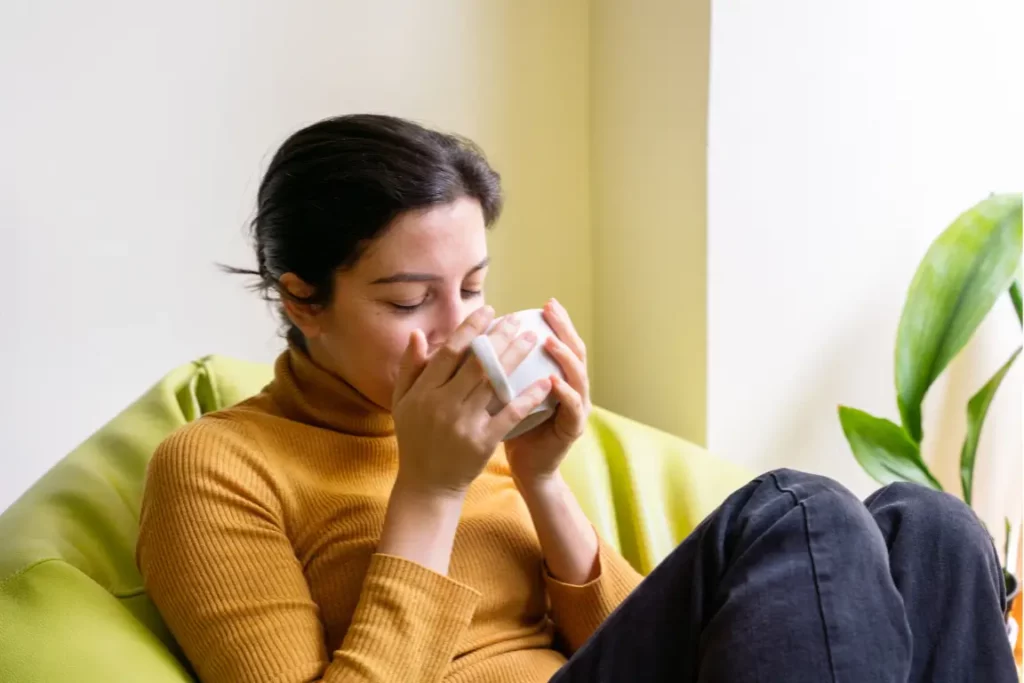 A woman sips on herbal tea for gut health