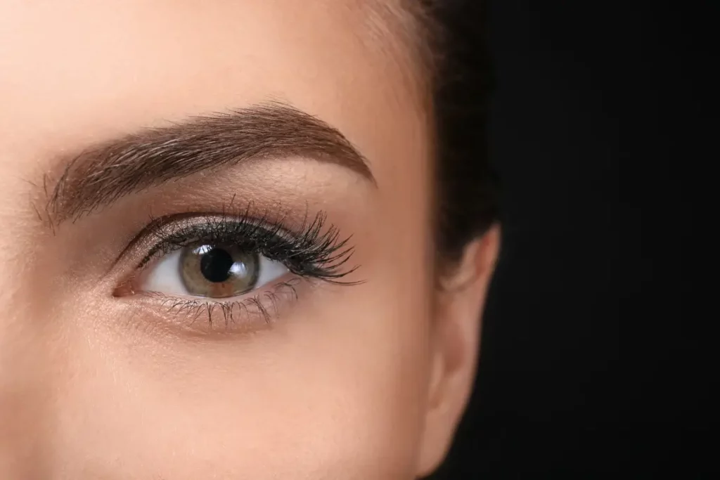 Are thick eyebrows genetic? A woman with thick eyebrows looks at the camera.